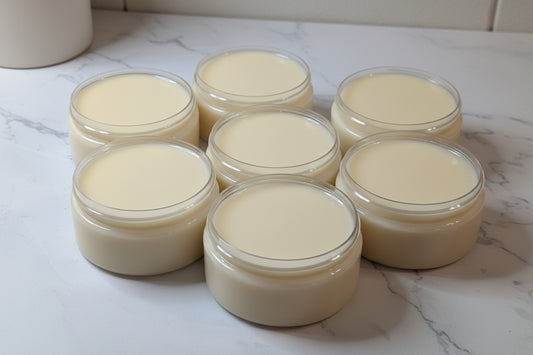 Six jars of a creamy substance on a white surface
