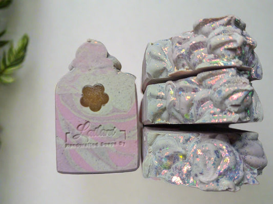 This image features a bar of soap named "Faded Romance Soap Bar." The soap has an intricate design with a mix of pastel colors—pale pink and purple swirls, highlighted with a subtle shimmer.