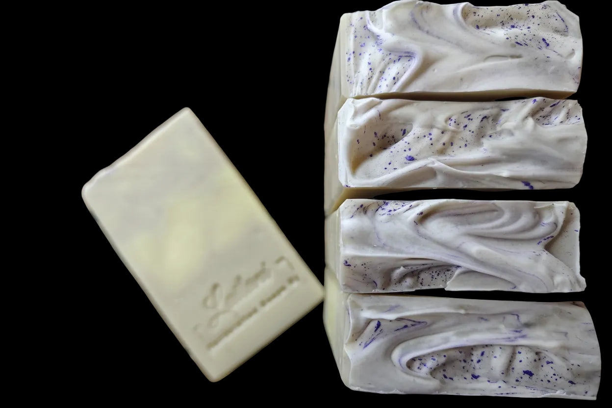 Handmade soap bars with visible branding on a wooden surface