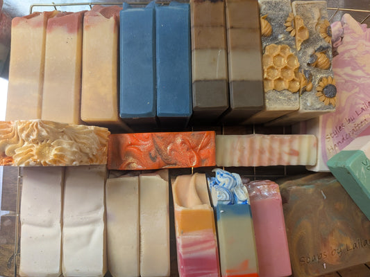 Stack of variously colored and textured soap bars on a display stand.