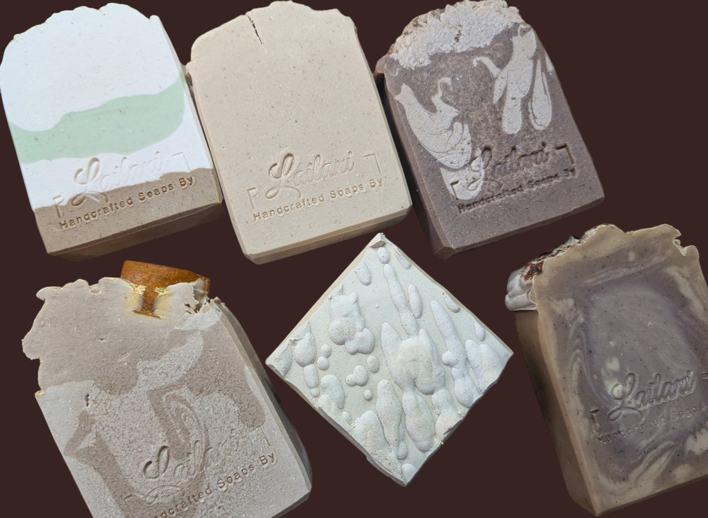 Assorted bars of soap with embossed designs on a wooden surface