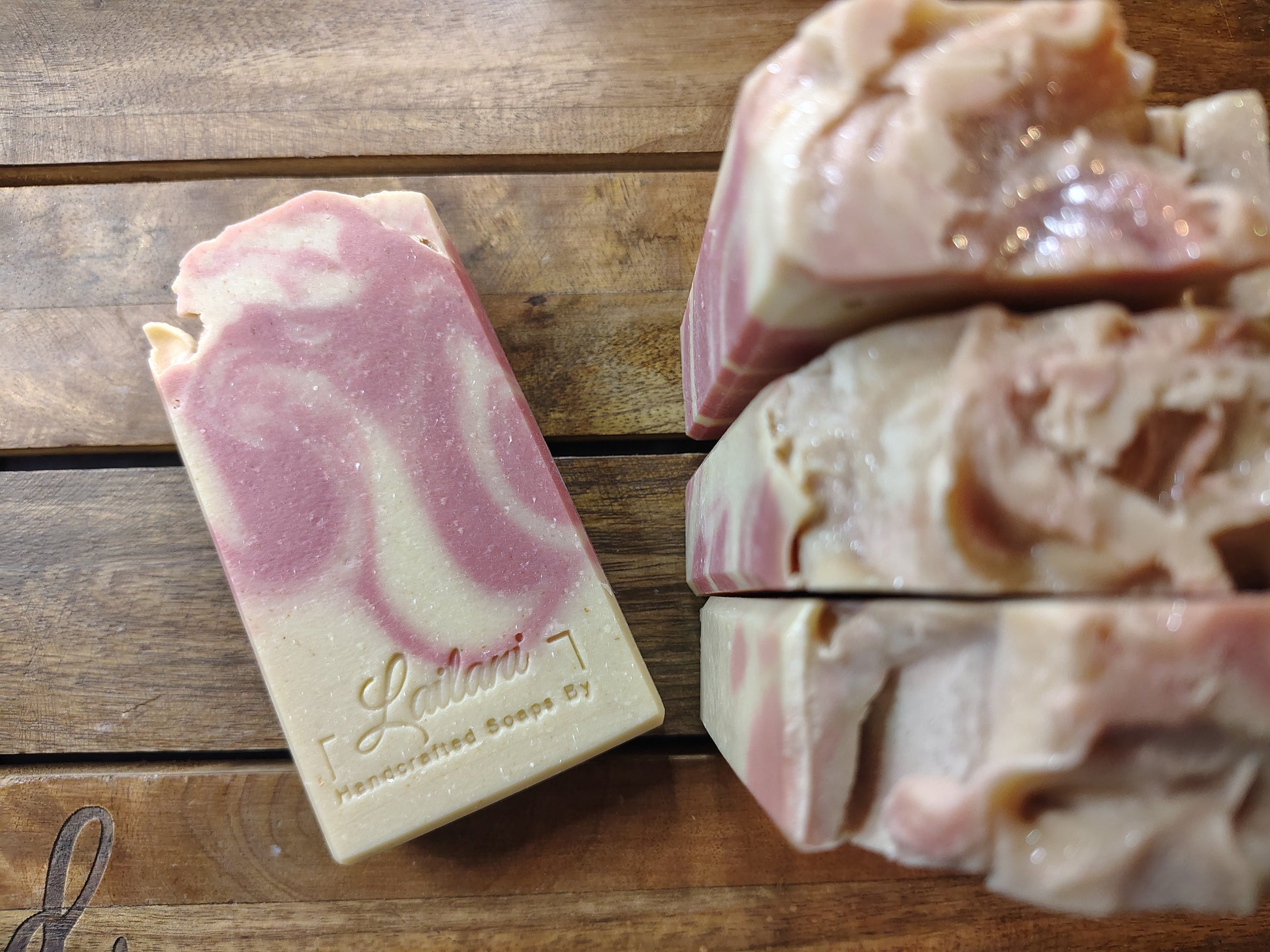 Bar of soap with a marbled design on a wooden surface, featuring the brand 'Lailani Soap Co'.