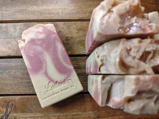 Bar of soap with a marbled design on a wooden surface, featuring the brand 'Lailani Soap Co'.